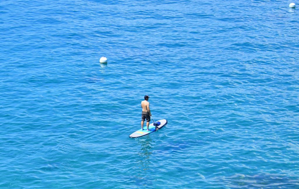man stand up paddling on body of water