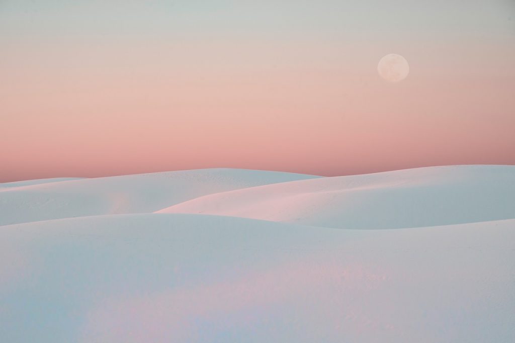 white sand dunes under pink sky