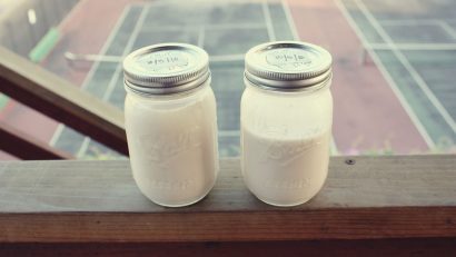 two jars with white almond milk outdoors