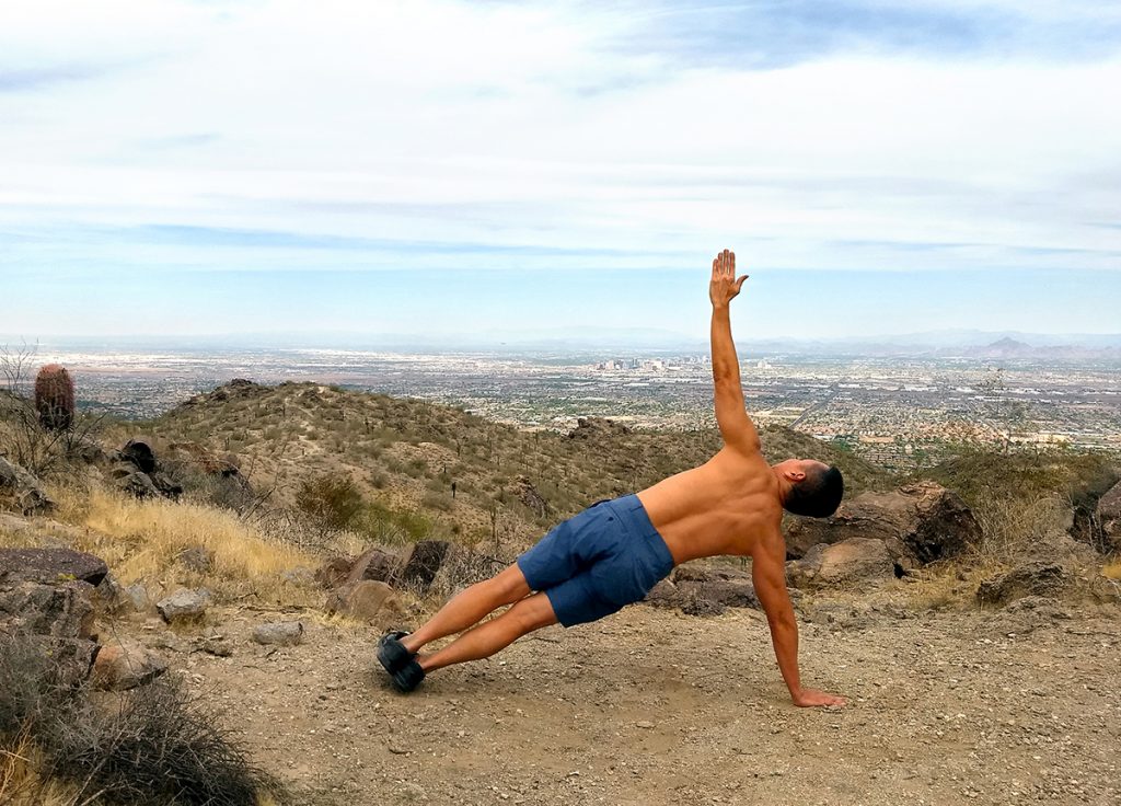 man doing side plank outdoors