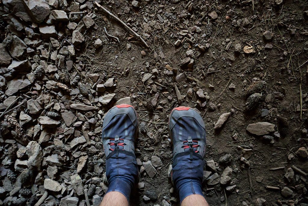 blue shoes with ankle gaiters on muddy trail