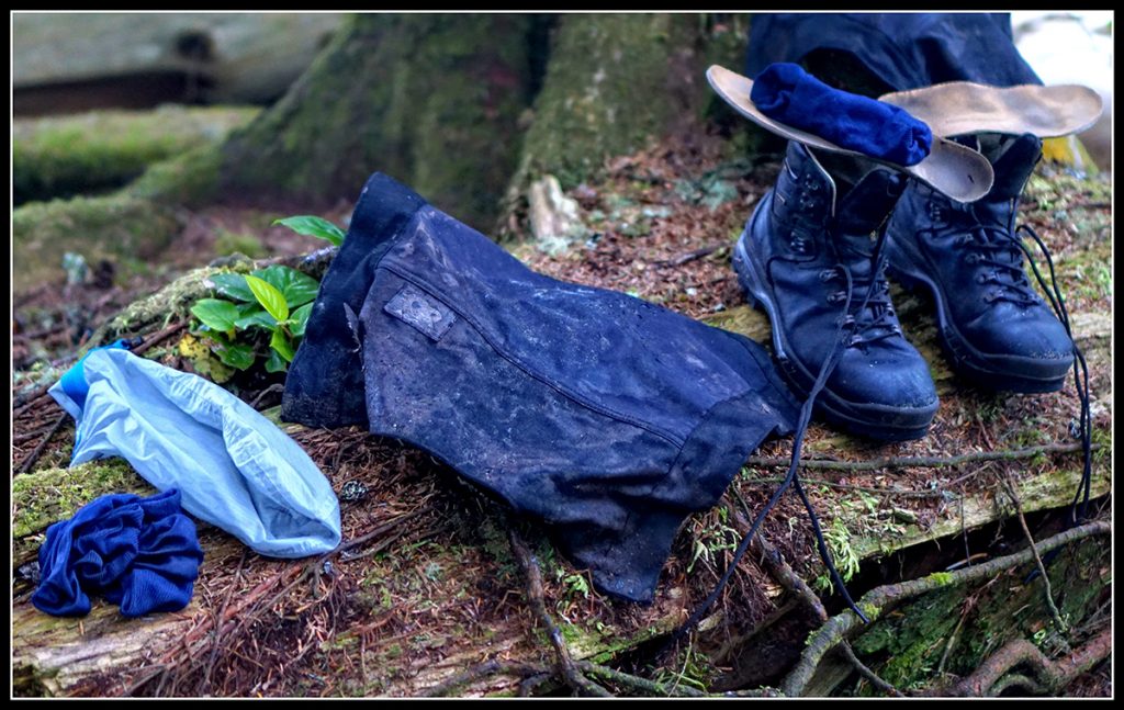 blue socks muddy gaiters and blue boots on a trunk