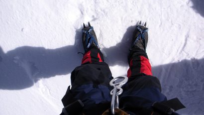 hiker wearing red and black leg gaiters in winter