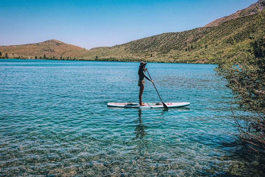 person in black riding on a paddle board a pa