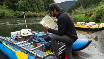 A man looking at a map before going on an whiterafting adventure in KUHL clothing for rafting