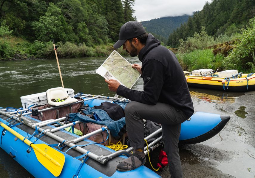 A man looking at a map before going on an whiterafting adventure in KUHL clothing for rafting
