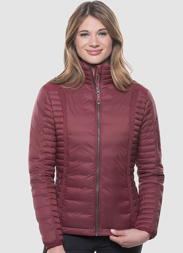 A studio photo of a woman wearing KUHL women's Spyfire Jacket in Cranberry Color